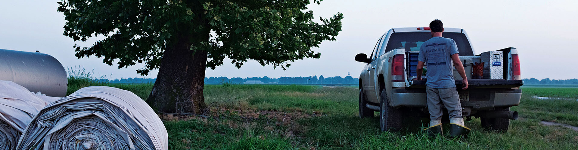 Farmer getting items from a truck while working a field. Farmer getting items from a truck while working a field.